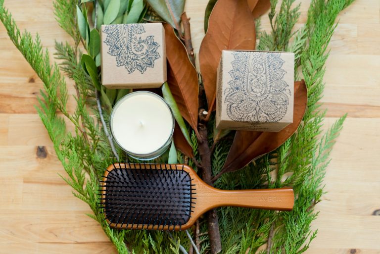 Brosse à cheveux en bois posée sur une table en bois, à côté d'une assiette blanche