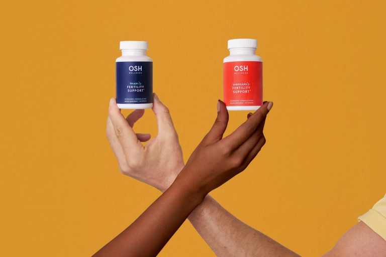 Femme tenant deux flacons de compléments alimentaires, illustrant le choix d'un complément pour les ongles